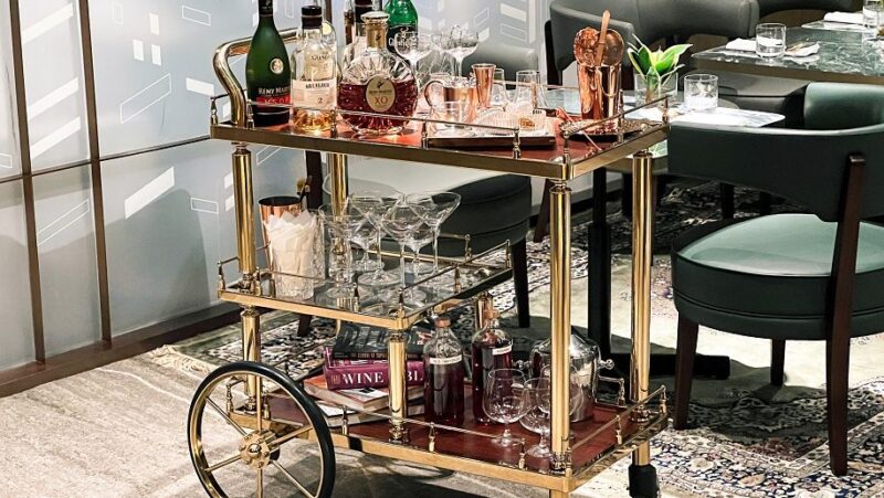 Gold whiskey trolley, full of drinking glasses and bottles of alcohol